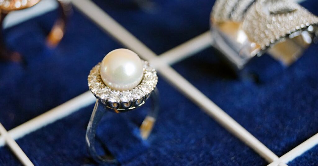 Close-up of a pearl ring with diamonds on a luxurious display.